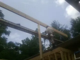Carpenter setting a ridge beam over a new addition frame — Ice Dam Removal by Roofing Brothers in South Hamilton