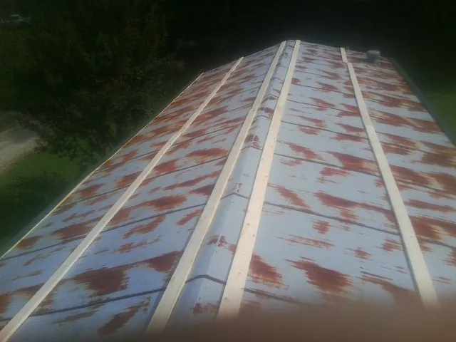 Rusted metal roof panels with new wood purlins before replacement — Storm Damage Roof Repair in South Hamilton by Roofing Brothers