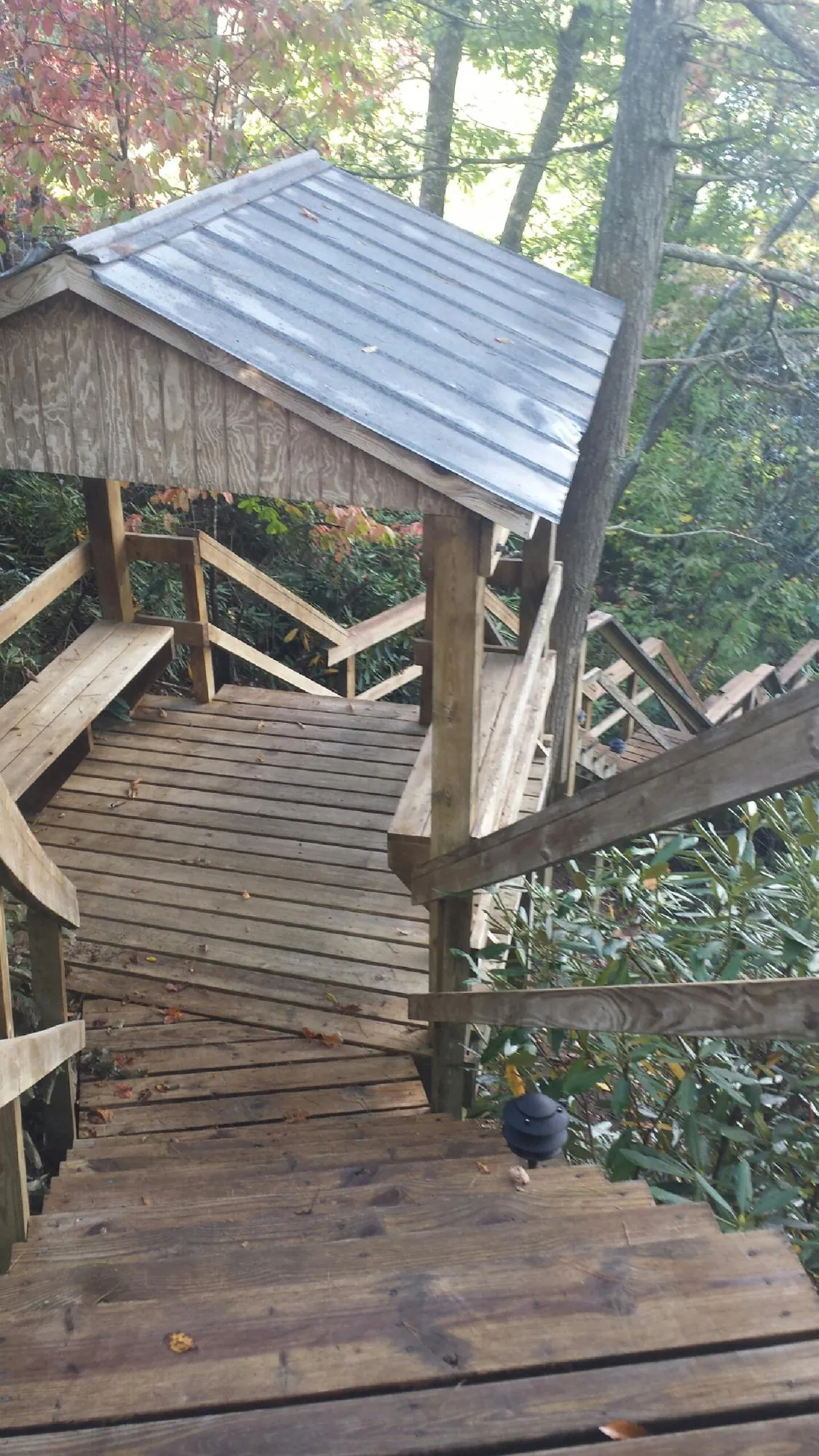 Metal roofed shelter over wooden steps on a wooded walkway — Skylight Repair & Installation work by our crew in South Hamilton