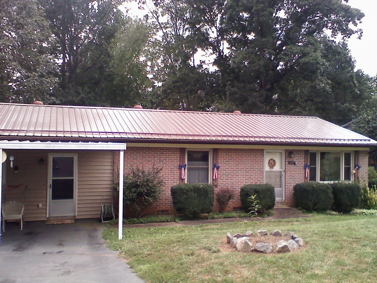 Bronze metal roof and carport on a brick ranch home — Roof Repair work by our crew in South Hamilton